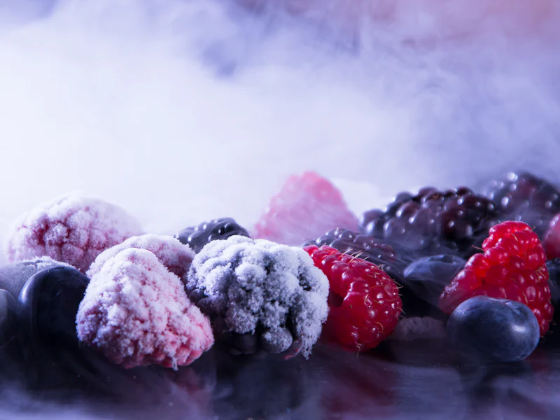 Frozen berries covered in frost, representing frozen fruit pulp supply.